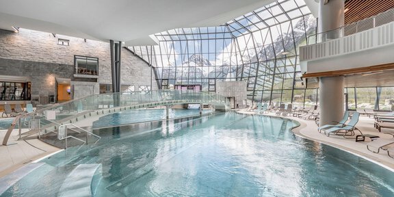 Ein eleganter Innenpool mit großen Fenstern und viel natürlichem Licht. Die moderne Architektur schafft eine entspannende Atmosphäre. - AQUA DOME - Tirol Therme Längenfeld - Längenfeld