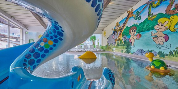 A colorful water slide tower in an indoor swimming pool. Cheerful drawings of animals and children can be seen on the walls. - Erlebnishallenbad Freizeit Arena - Sölden