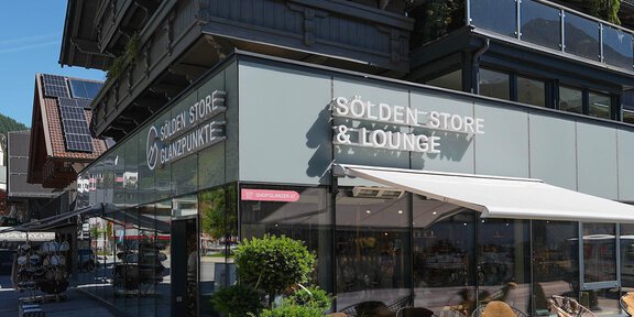 Ein modernes Geschäft mit der Aufschrift "Sölden Store & Lounge". Draußen stehen bequeme Stühle und es ist schönes Wetter. - Sölden Store - Glanzpunkte | Shop 9 - Sölden