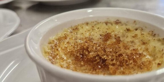 A creative dessert presentation in a small white bowl. The dessert is topped with a crispy surface and fresh raspberries. - Hochjoch Hospiz - Vent