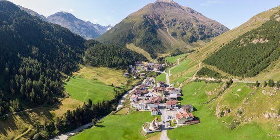 Eine malerische Berglandschaft mit einem kleinen Dorf in einem Tal. Grüne Wiesen und majestätische Berge umgeben die Siedlung. - 6er Sesselbahn Wildes Mannle - Vent