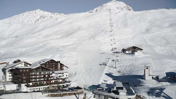 Schneebedeckte Berge mit Skiliften und einem charmanten Hotel im Vordergrund. Die Landschaft strahlt eine ruhige Winteratmosphäre aus. - TOP Hotel Hochgurgl - Hochgurgl