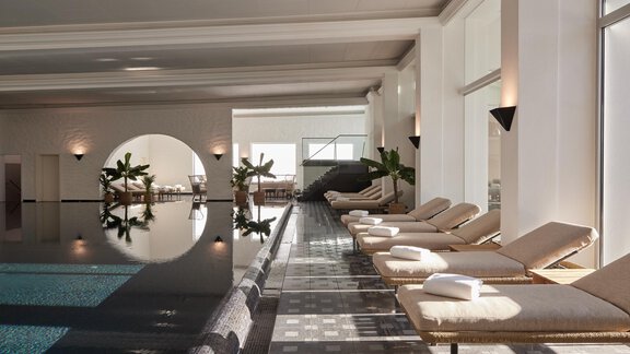 Ein elegantes Spa mit einem ruhigen Innenpool und bequemen Liegen. Die große Fensterfront lässt viel natürliches Licht herein und schafft eine entspannende Atmosphäre. - TOP Hotel Hochgurgl - Hochgurgl