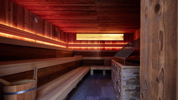 Eine moderne Sauna mit Holzverkleidung und sanfter Beleuchtung. Bänke bieten Platz zum Entspannen. - TOP Hotel Hochgurgl - Hochgurgl