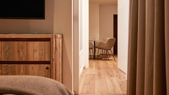 Ein moderner Raum mit Holzboden und einem gemütlichen Schrank. Im Hintergrund sind ein Essbereich und eine Tür sichtbar. - TOP Hotel Hochgurgl - Hochgurgl