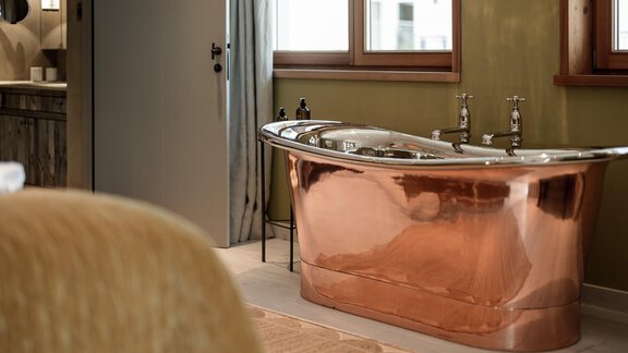 An elegant copper bathtub in a modern bathroom. Large windows provide plenty of natural light and create a relaxing atmosphere. - Chalet Cecilia by MYALPS - Obergurgl 