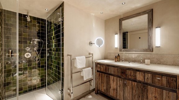 A modern bathroom with a stylish shower and a wooden washbasin. The walls are painted in neutral tones, and there is plenty of light from the ceiling lighting. - Chalet Cecilia by MYALPS - Obergurgl 