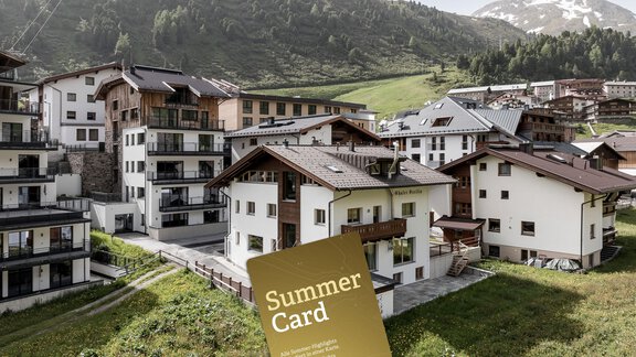 A picturesque mountain landscape with modern chalets and green meadows. In the foreground, a summer map lies on the grass. - Chalet Cecilia by MYALPS - Obergurgl 