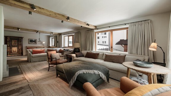 A cozy living room with comfortable sofas and a modern design. Large windows let in plenty of light and provide a view outside. - Chalet Cecilia by MYALPS - Obergurgl 