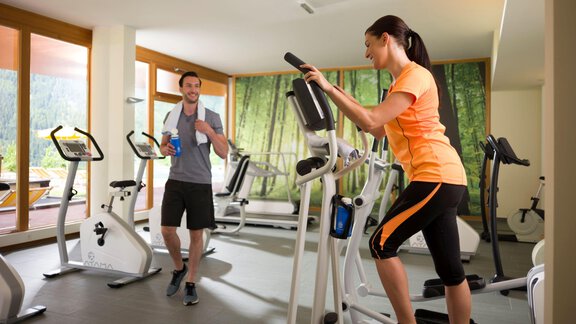 A modern gym with two people training. One person is using a treadmill while the other is training with weights. - Vivea 4* Hotel Umhausen im Ötztal - Umhausen
