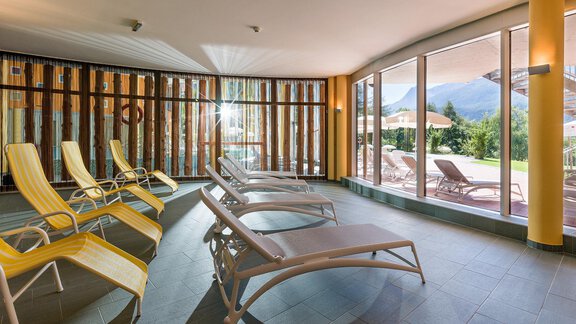 A relaxing wellness area with loungers and large windows. The room is bright and cozy, ideal for relaxing. - Vivea 4* Hotel Umhausen im Ötztal - Umhausen