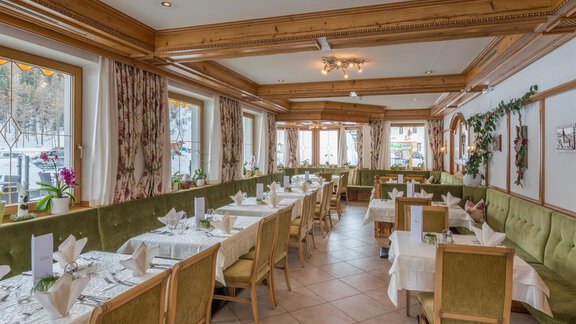 Ein einladendes Restaurant mit eleganten Tischen und Stühlen. Große Fenster lassen viel Licht herein und schaffen eine angenehme Atmosphäre. - Hotel Tauferberg - Niederthai