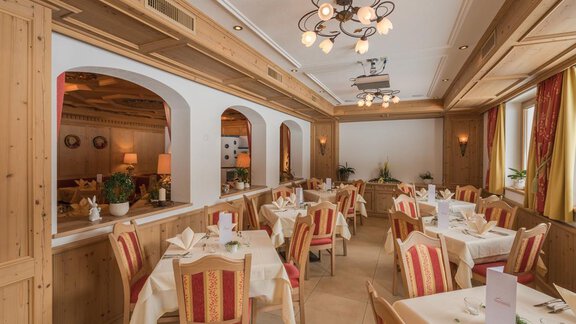 Ein gemütliches Restaurant mit Holzelementen und eleganten Tischen. Die Atmosphäre ist einladend und warm. - Hotel Tauferberg - Niederthai