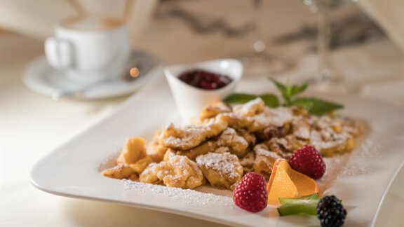 Eine köstliche Portion Kaiserschmarrn mit Puderzucker und frischen Beeren. Daneben ein Becher mit Konfitüre und ein Kaffee. - Hotel Tauferberg - Niederthai