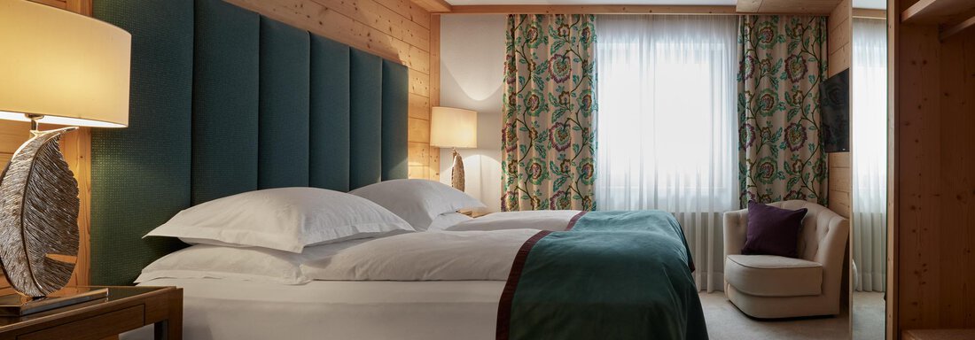 Tophotel Cosy Room | © TOP Hotel Hochgurgl (CC C) Ein gemütliches Hotelzimmer mit zwei Betten, einem modernen Nachttisch und einer Lampe. Große Fenster lassen viel Licht herein und bieten eine angenehme Atmosphäre. - TOP Hotel Hochgurgl - Hochgurgl