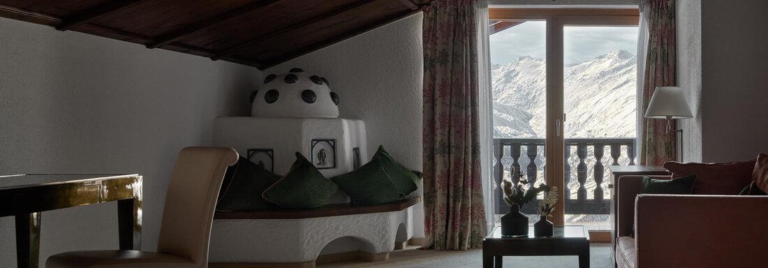 Ein gemütliches Zimmer mit einem Holzdecke und großen Fenstern. Der Raum hat eine einladende Atmosphäre und bietet einen Blick auf die Berge. - TOP Hotel Hochgurgl - Hochgurgl