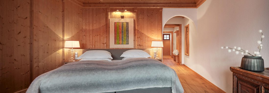 Family 2 Bedroom Suite Mountain View | © TOP Hotel Hochgurgl (CC C) Ein modernes Schlafzimmer mit Holzverkleidung und einem großen Bett. Der Raum ist hell und einladend, mit einer künstlerischen Wanddekoration. - TOP Hotel Hochgurgl - Hochgurgl