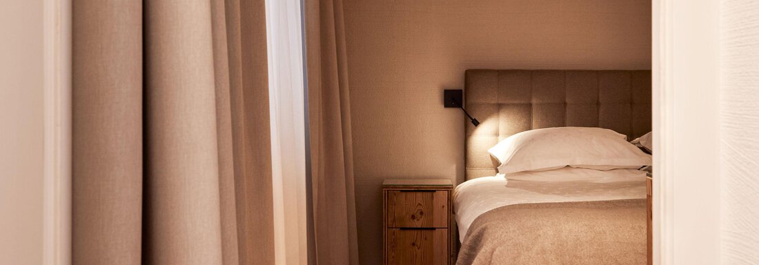 Junior Suite Sauna | © TOP Hotel Hochgurgl (CC C) Ein gemütliches Schlafzimmer mit einem großen Bett und sanften Farben. Die warmen Vorhänge und der Holzboden schaffen eine einladende Atmosphäre. - TOP Hotel Hochgurgl - Hochgurgl