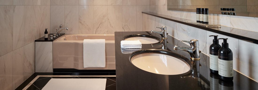 Ein modernes Badezimmer mit eleganten Marmorwänden und einem stilvollen Waschbecken. Die Badewanne und die dekorativen Accessoires bieten eine luxuriöse Atmosphäre. - TOP Hotel Hochgurgl - Hochgurgl