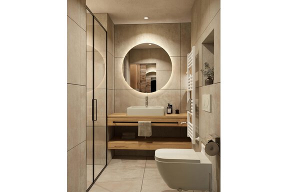 Ein modernes Badezimmer mit klaren Linien und neutralen Farben. Es verfügt über eine elegante Dusche, ein Waschbecken auf einer Holzablage und einen runden Spiegel. - Hotel Tauferberg - Niederthai