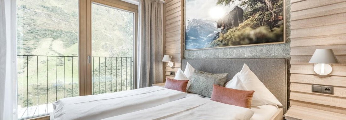Ein modernes Schlafzimmer mit einem großen Bett und gemütlichen Kissen. Große Fenster bieten einen Blick auf die beeindruckende Berglandschaft draußen. - Chalet Obergurgl luxury apartments - Obergurgl 