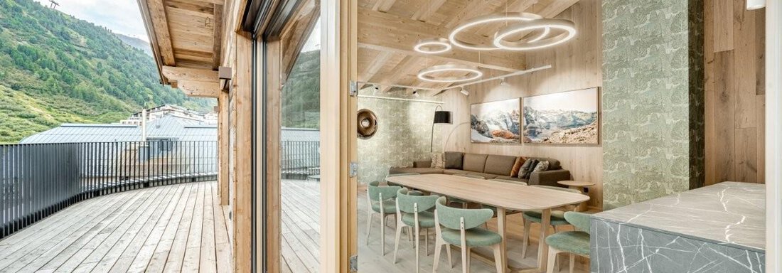 Ein modernes Wohnambiente mit großen Fenstern und natürlichem Licht. Im Hintergrund sind die Berge zu sehen, während ein eleganter Esstisch den Raum ergänzt. - Chalet Obergurgl luxury apartments - Obergurgl 