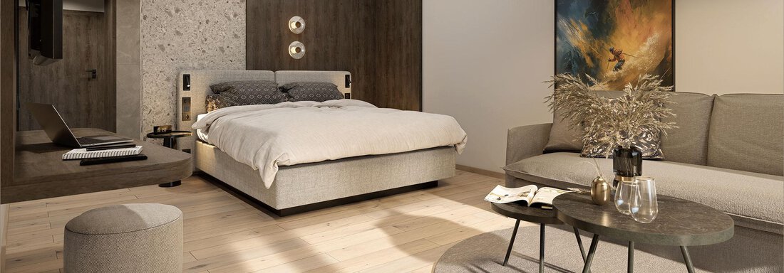 A modern bedroom with a large bed and a cozy sofa. The decor is bright and stylish, featuring a round rug and a table. - Ferienwohnung de Luxe Alpenresidenz am Mühlbach - Obergurgl 