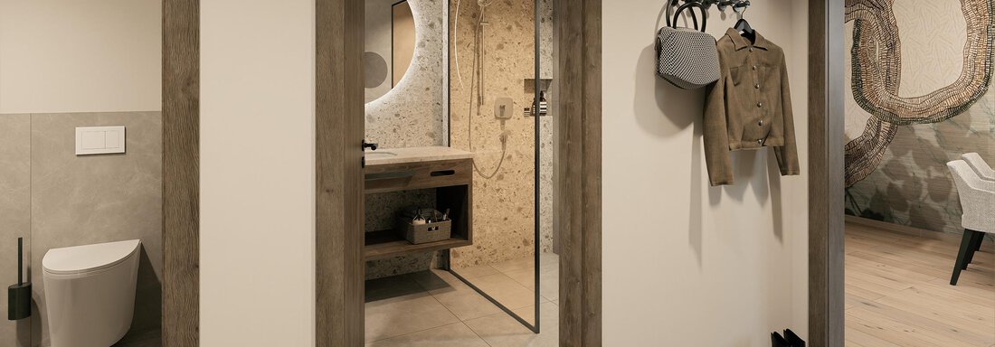 A modern bathroom with elegant design and bright tiled floor. Through the open doors, a stylish shower and a cloakroom in the entrance area are visible. - Ferienwohnung de Luxe Alpenresidenz am Mühlbach - Obergurgl 