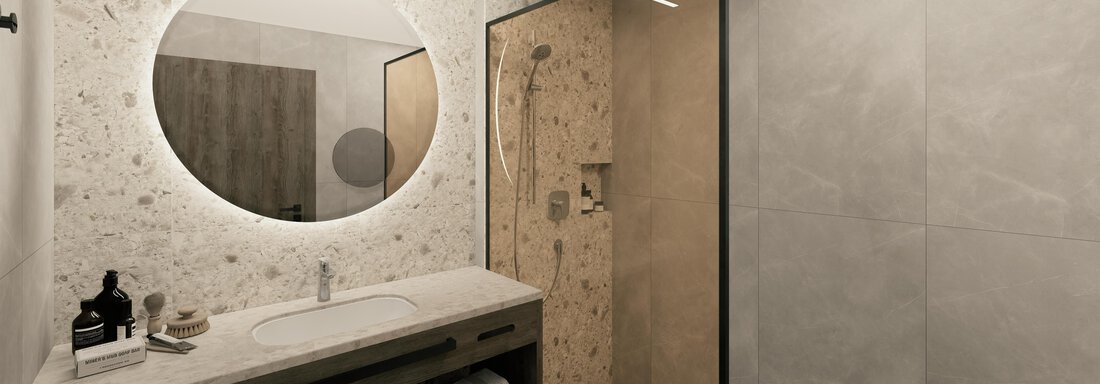 A modern bathroom with a large round mirror light and a walk-in shower. The walls are in neutral colors, and the decor is simple and elegant. - Ferienwohnung de Luxe Alpenresidenz am Mühlbach - Obergurgl 