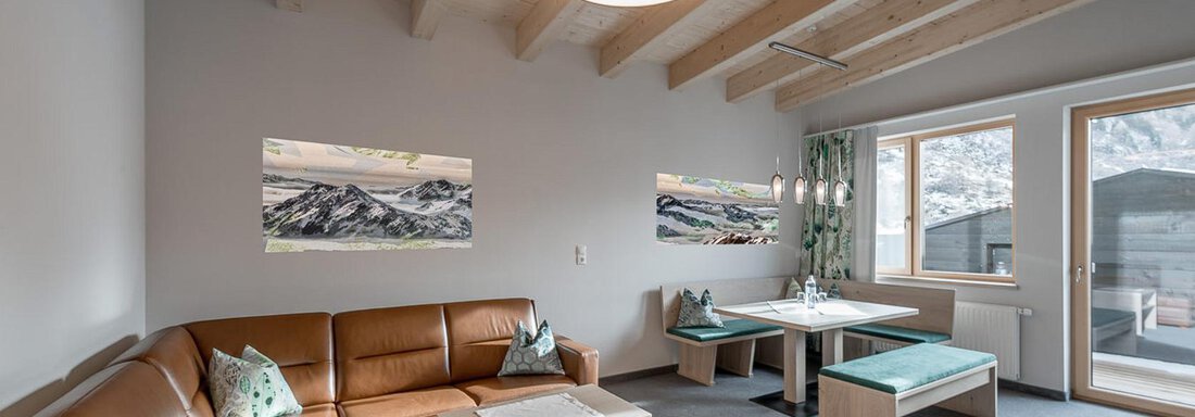 Penthouse Suite "402" Ein modernes Wohnzimmer mit einer gemütlichen Ledercouch und einem Essbereich. Helle Wände und hölzerne Decken verleihen dem Raum eine einladende Atmosphäre. - Skihotel Haus Gurgl - Obergurgl